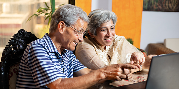 Older couple looking at retirement account with satisfaction